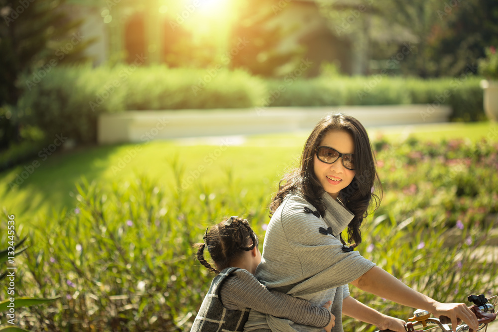 Mother and a daughter cycling bicycle at the park