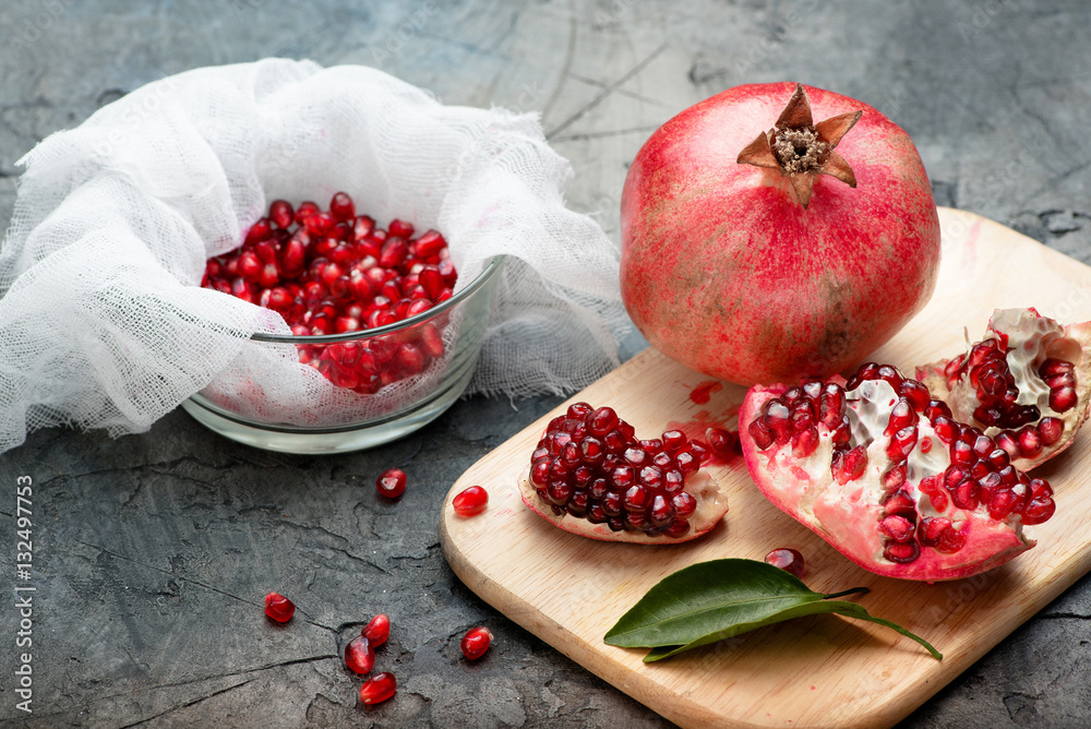 Pomegranate fruits with grains and leaves on the table. Make juice.