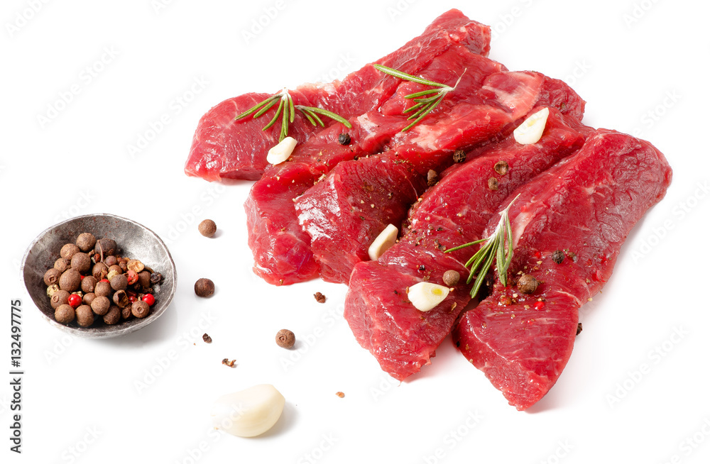 Pieces of meat with garlic and rosemary isolated on white background. Raw beef. Top view.