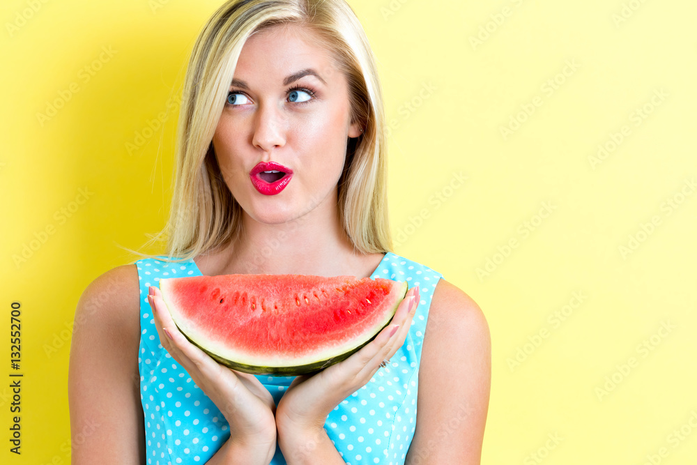 Happy young woman holding watermelon