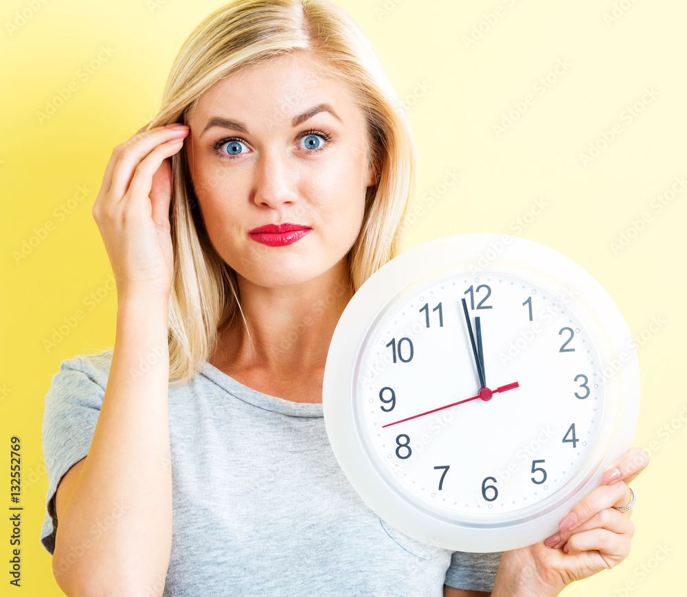  Woman holding clock showing nearly 12