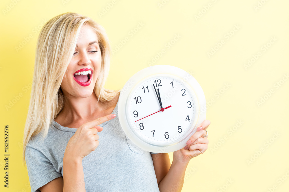  Woman holding clock showing nearly 12