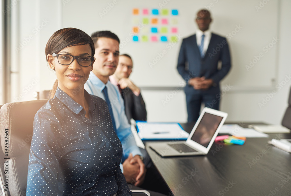 Grinning woman seated with colleagues in meeting