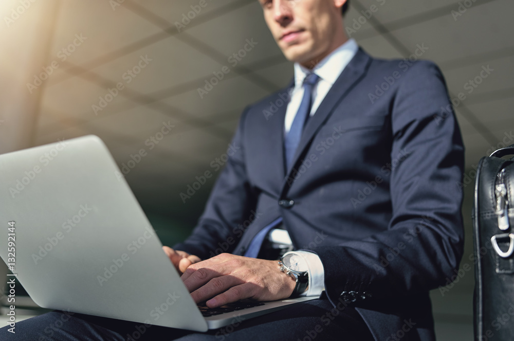 Confident businessman works with his gray notebook