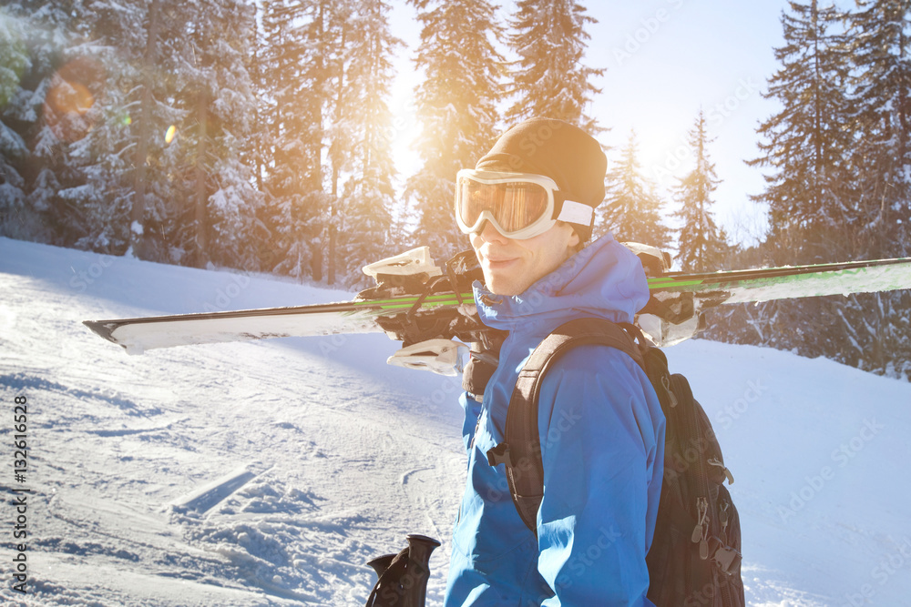 portrait of young happy smiling skier in goggles, active winter holidays