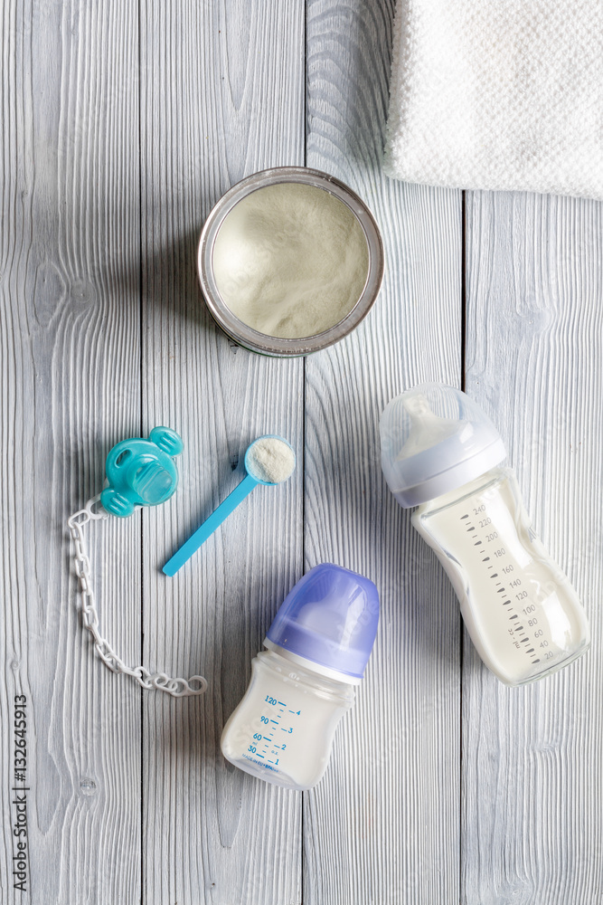 preparation of mixture baby feeding on wooden background top view