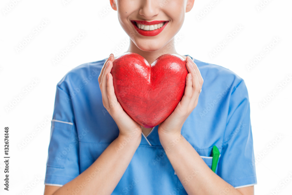 Female cardiologist in uniform holding red heart isolated on the white background