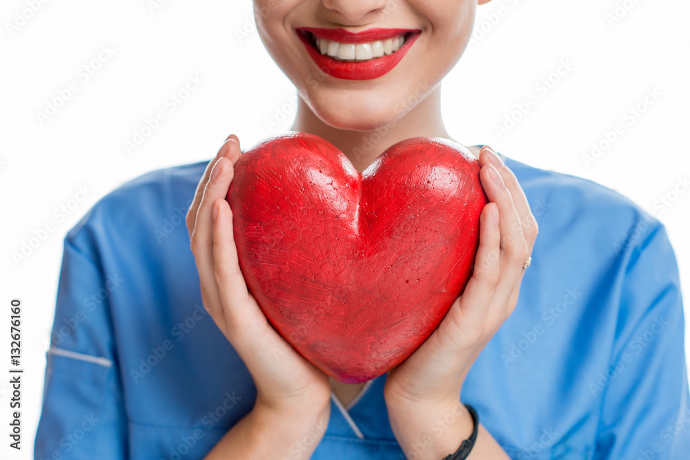 Female cardiologist in uniform holding red heart isolated on the white background