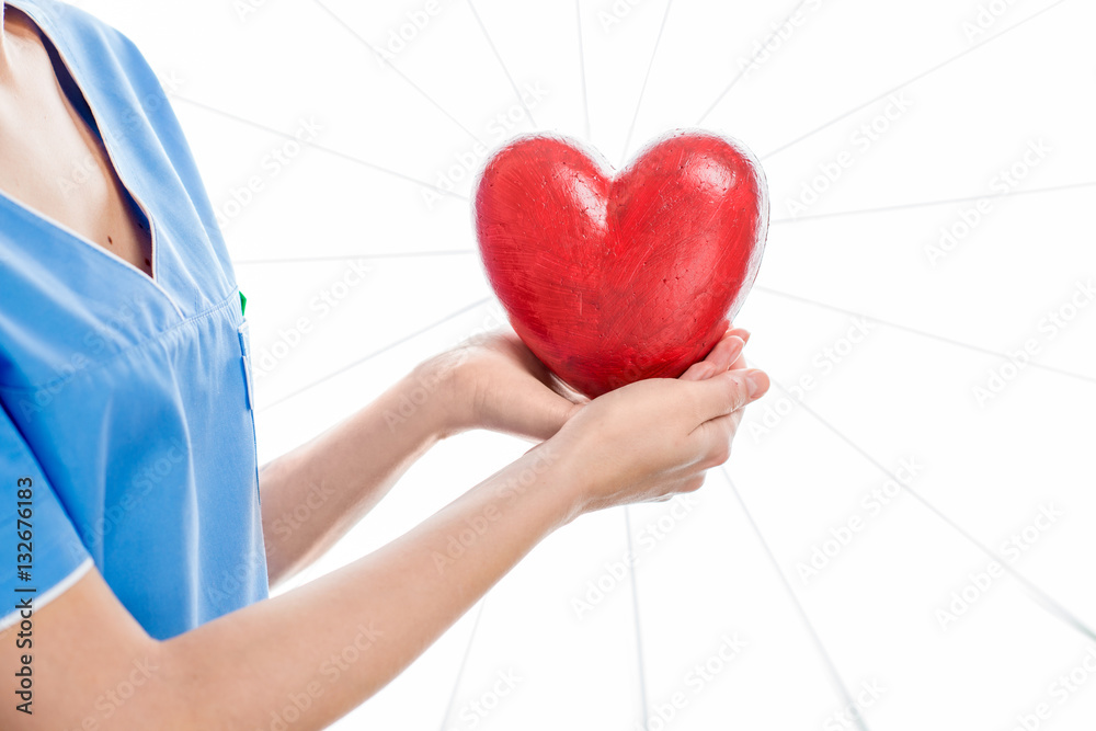 Female cardiologist in uniform holding red heart isolated on the white background. Close up view on 