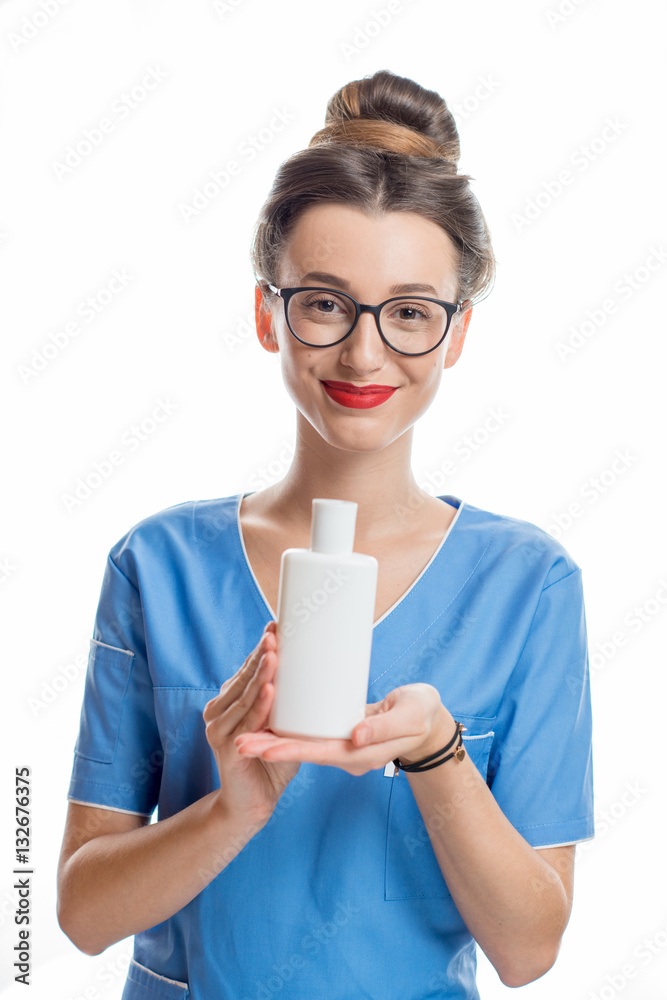 Portrait of a young smiling cosmetologist holding a bottle with cosmetics. Studio shot isolated on w