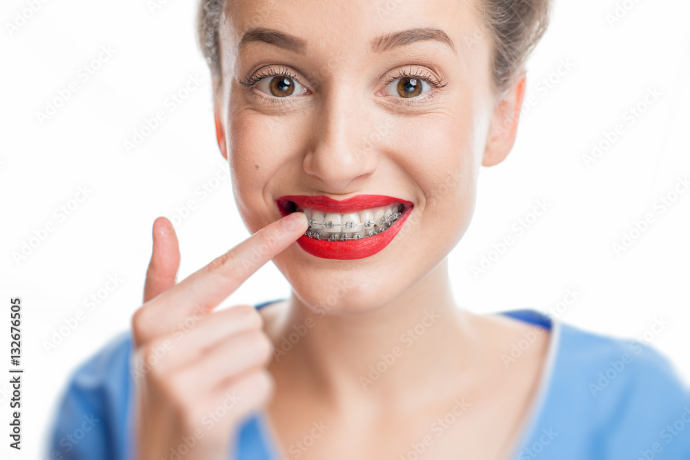 Close up portrait of smiling woman with tooth braces. Studio shot on the white background