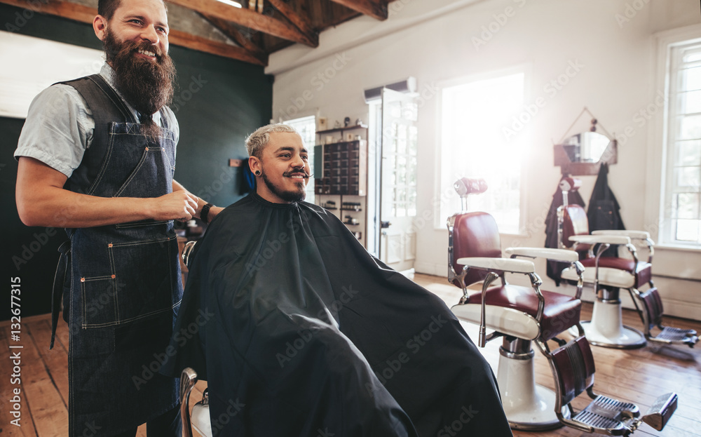 Hipster man getting haircut at barber shop