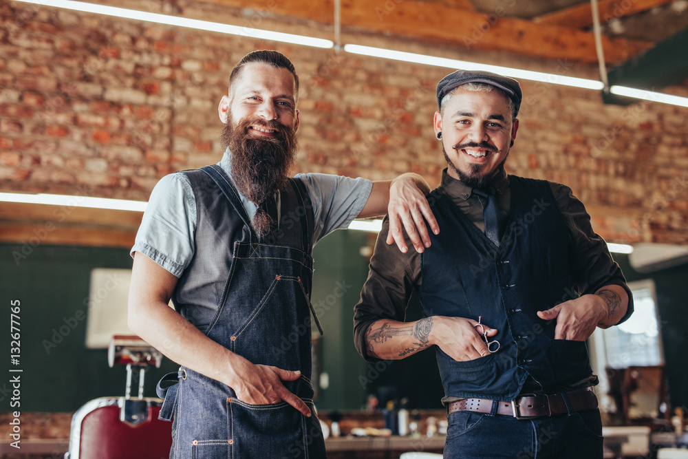 Barber with satisfied client at barbershop