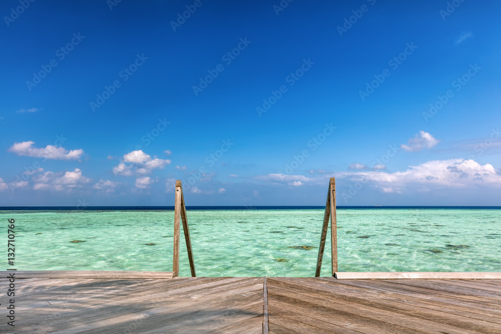 Wooden jetty towards water villas in Maldives.