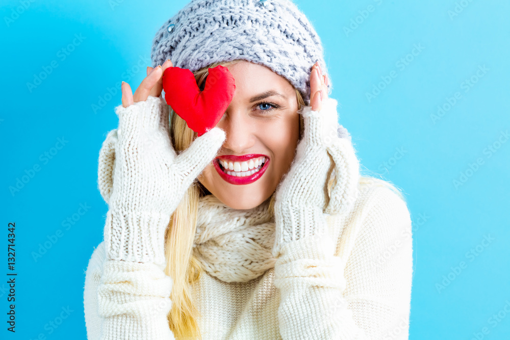 Happy young woman holding a heart cushion