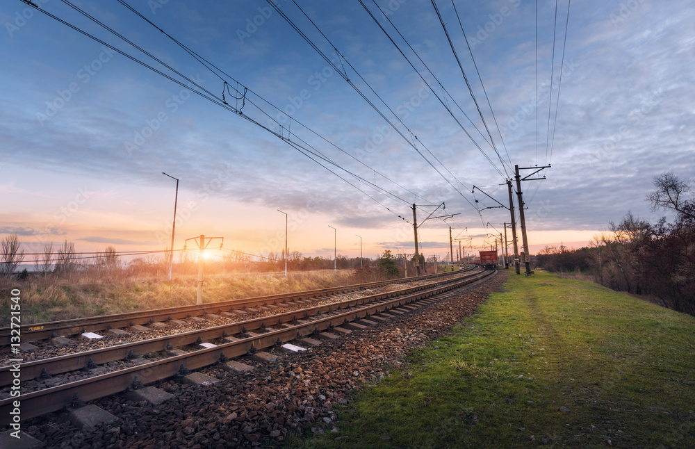 Railway station against beautiful sunny sky. Industrial landscape with railroad, blue sky and colorf