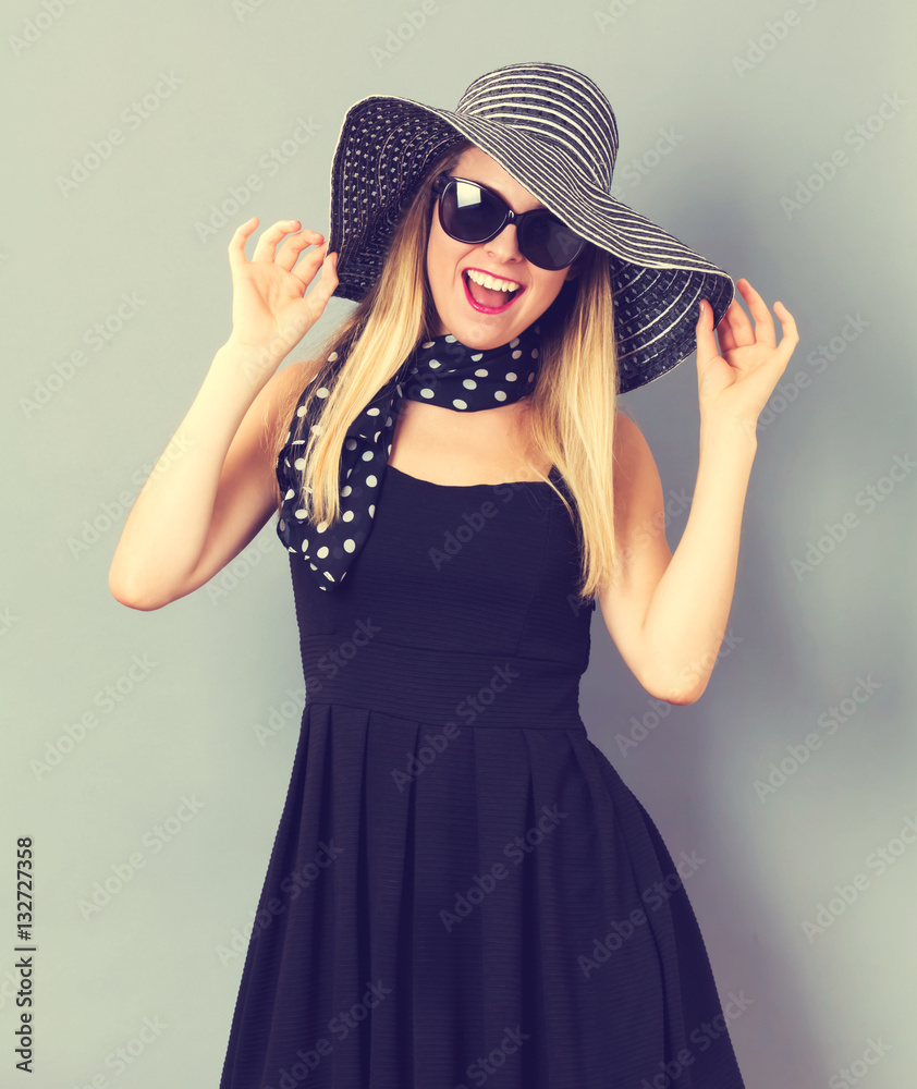 Happy young woman wearing a hat and sunglasses