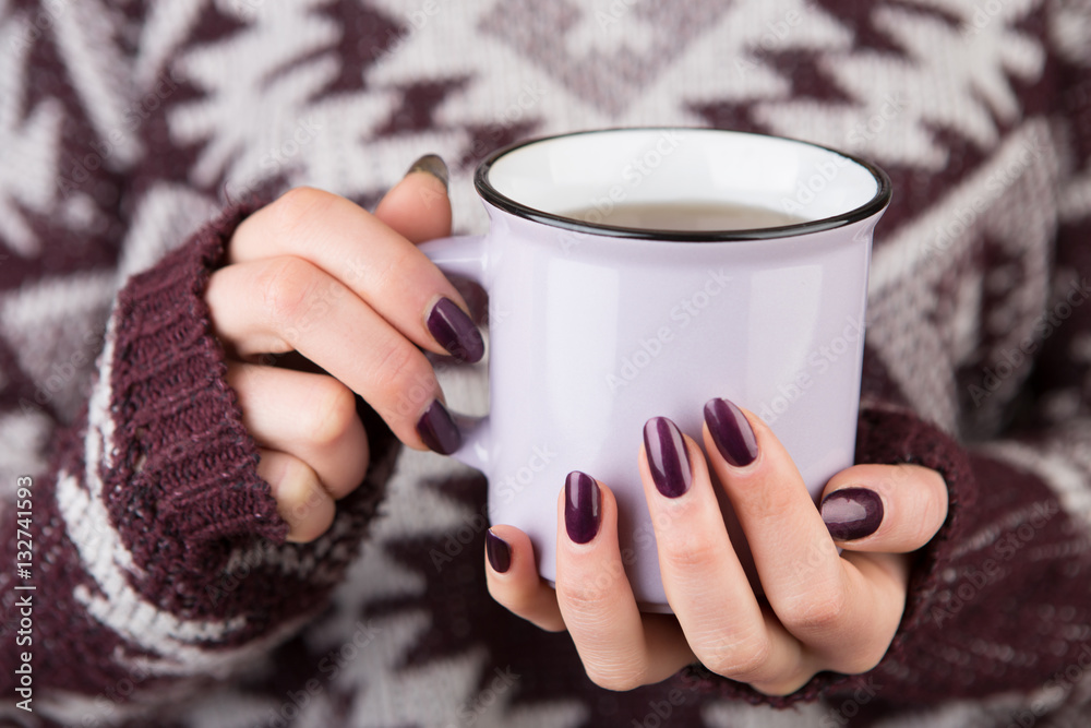 Woman in cozy sweater holding a cup