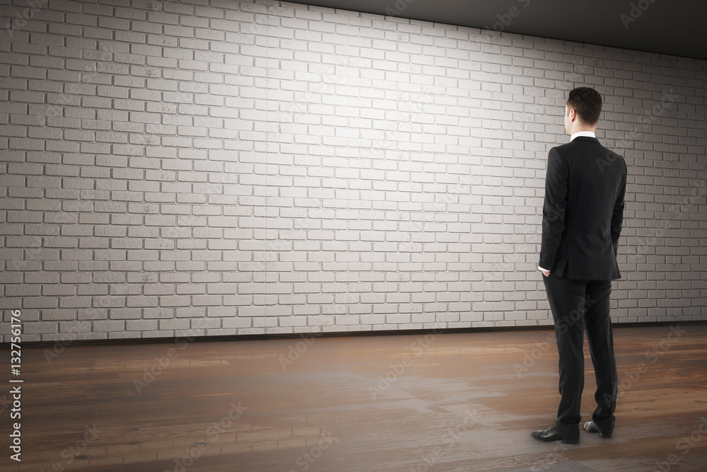 Businessman looking at empty brick wall