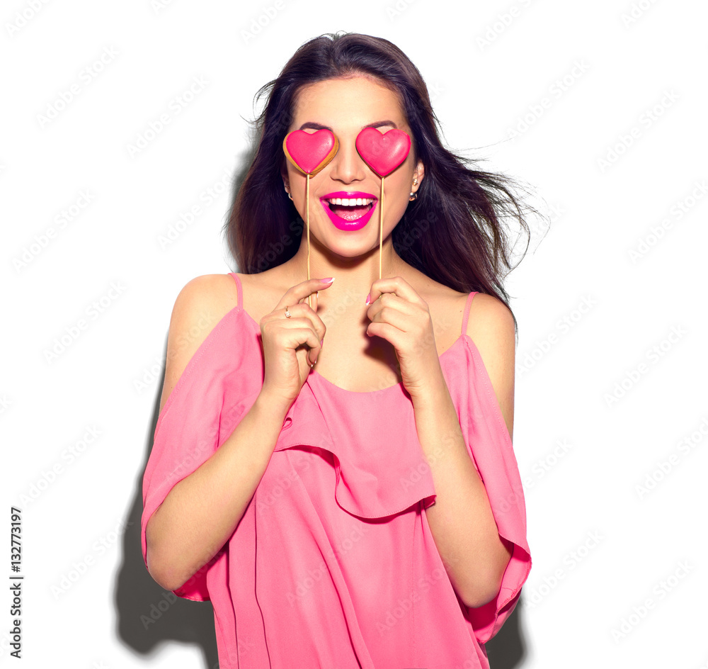 Valentines Day. Beauty joyful young fashion model girl with Valentine Heart shaped cookies in her ha