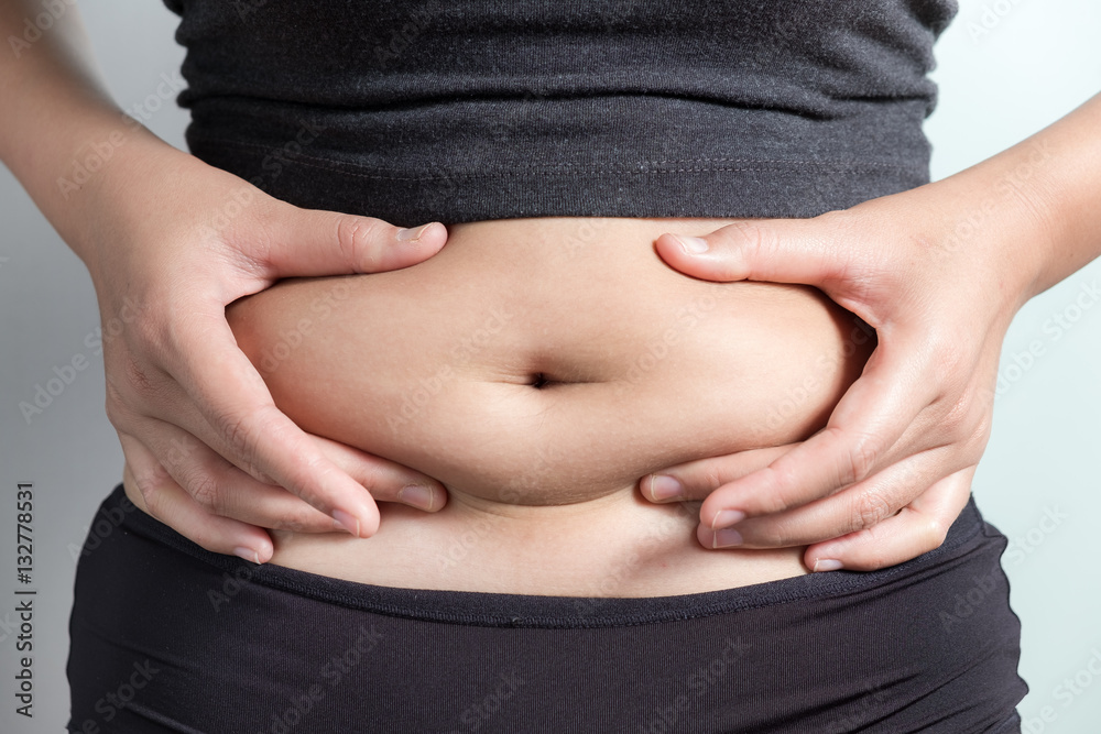 Pregnancy or diet concept, female hands protecting the stomach on white background.