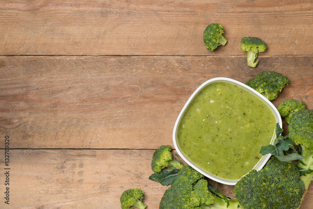 Tasty broccoli soup on a wooden background