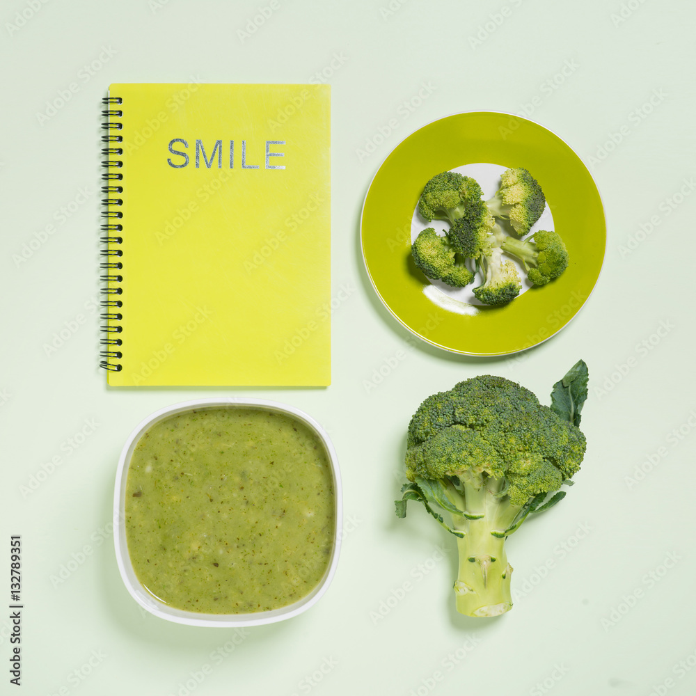 Tasty broccoli soup on a green background