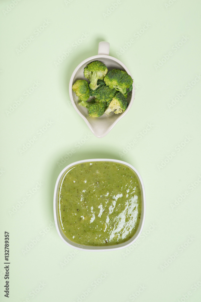 Tasty broccoli soup on a green background