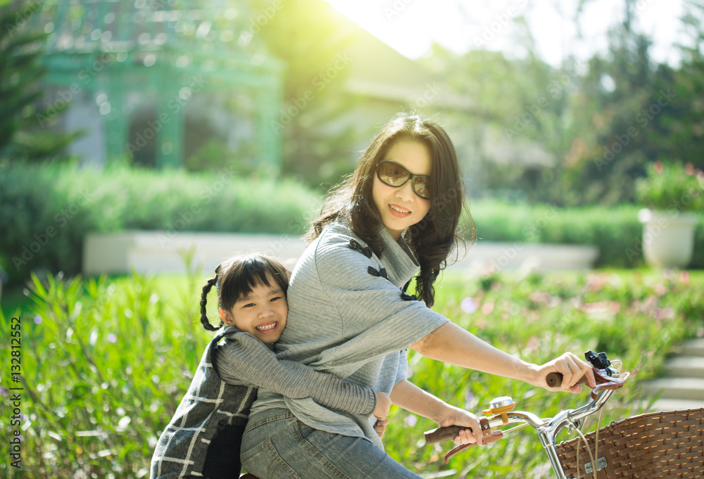 Mother and a daughter cycling bicycle at the park