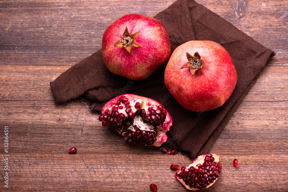 Pomegranate fruits with grains on wooden table. Top view.