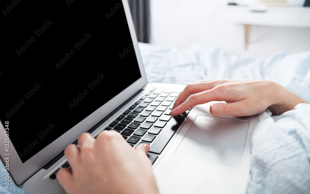 Young girl using laptop at home close up