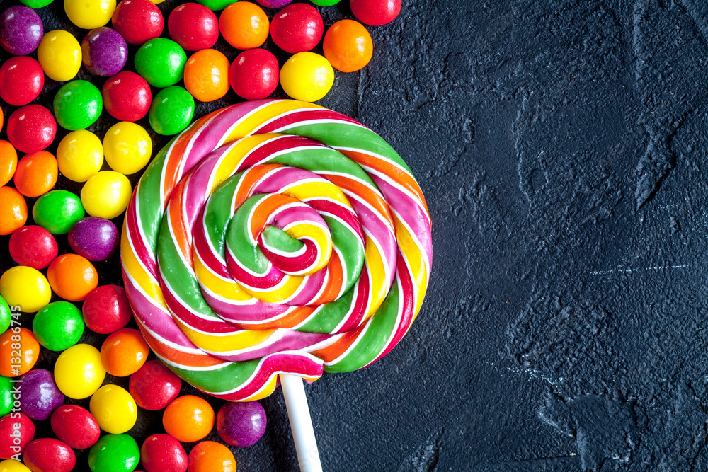 sweets and sugar candies on dark background top view