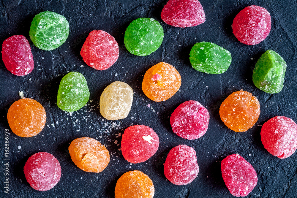 sweets and sugar candies on dark background top view