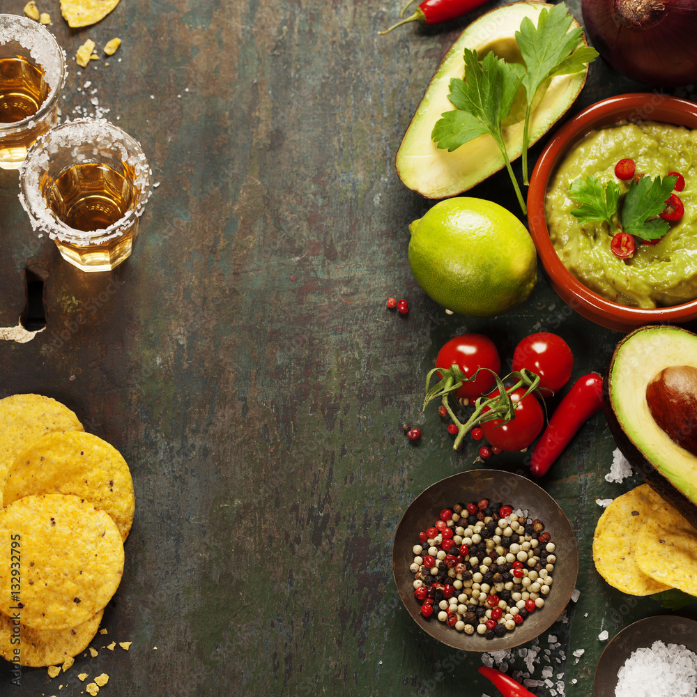 Bowl of guacamole with fresh ingredients and tequila shots