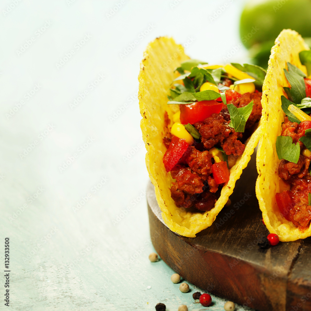 Mexican nachos chips and tacos with meat, beans and salsa