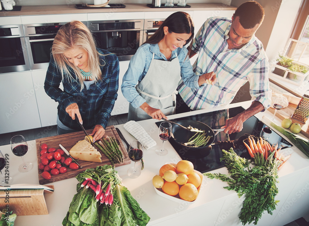 Three friends cooking at kitchen