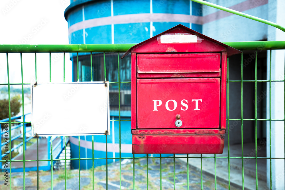 red post box on steel wall