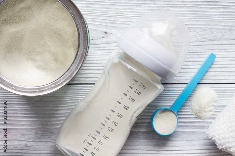 preparation of mixture baby feeding on wooden background top view