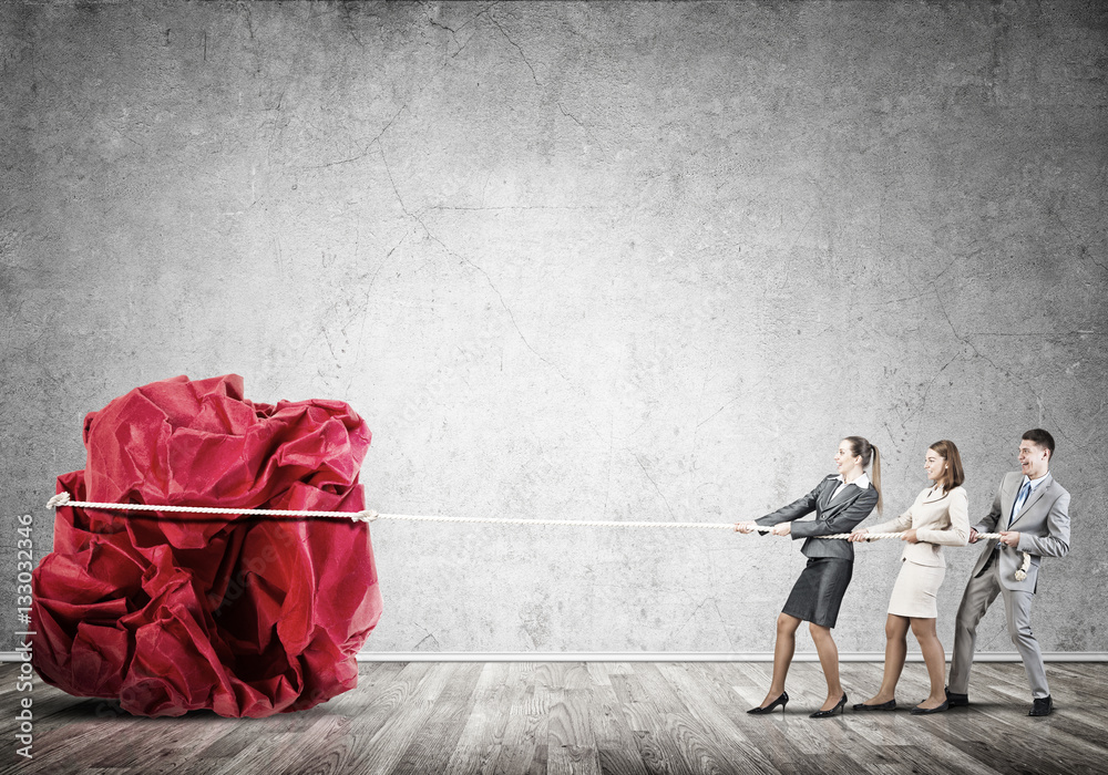 Young business people and huge paper ball as symbol of creativity