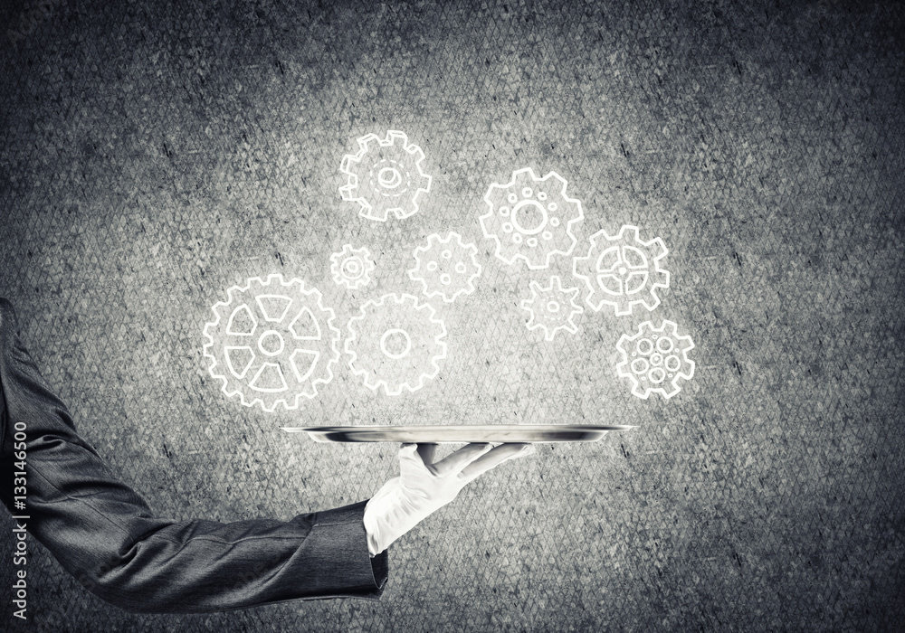 Waiter hand with empty silver tray and drawn gears concept