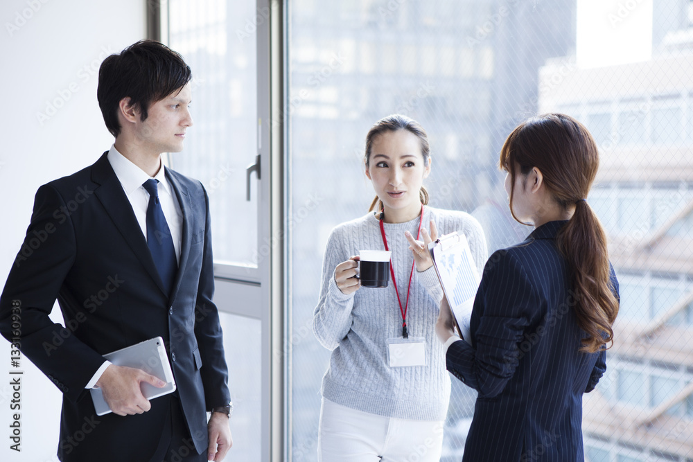 Young businessmen are talking on the window at the office