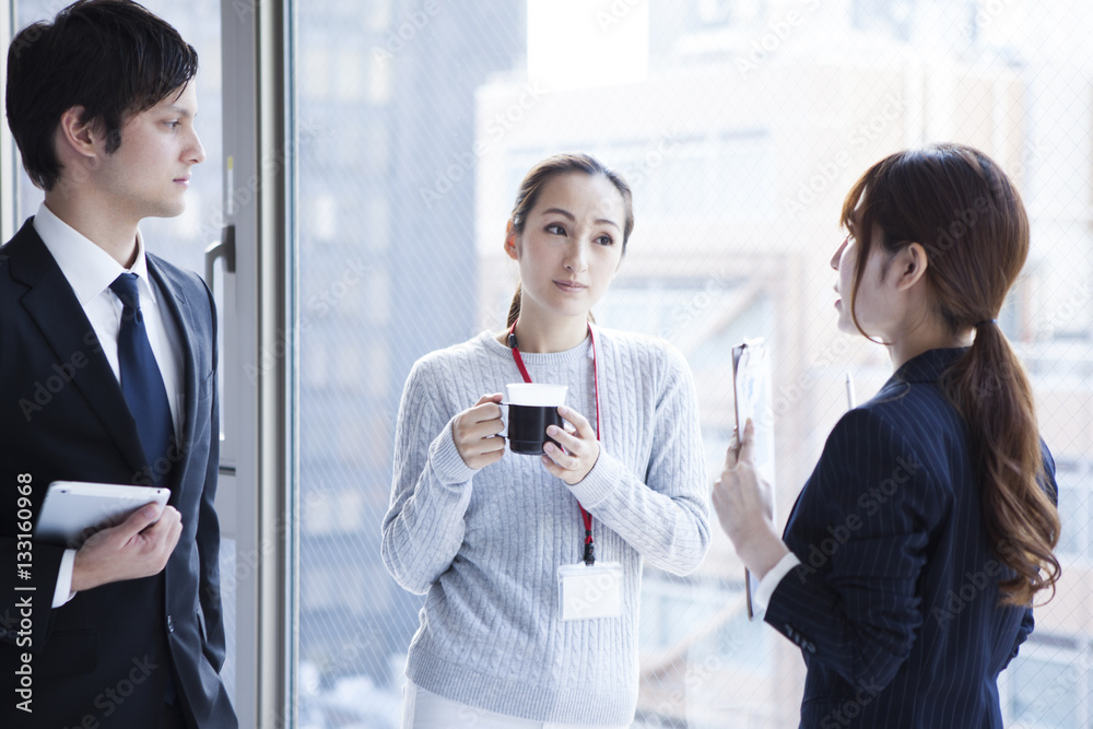 Young businessmen are talking on the window at the office