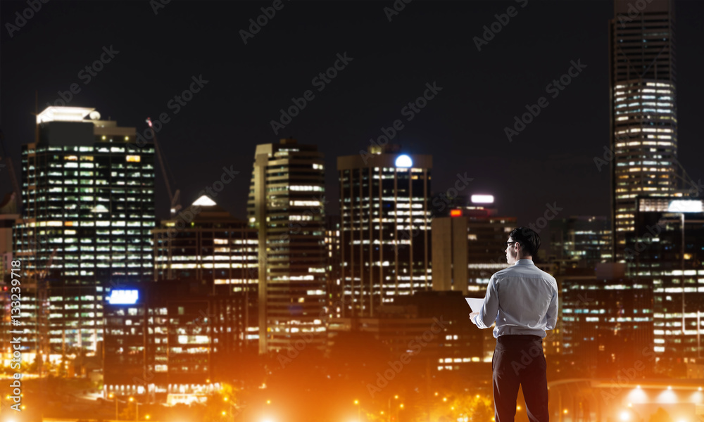 Businessman viewing night glowing city