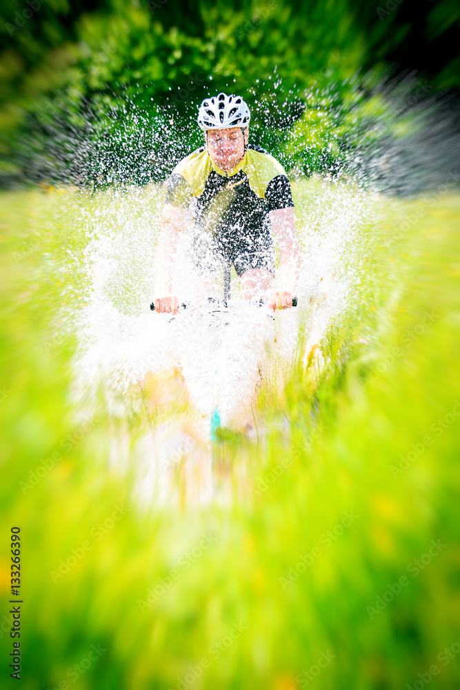 Mountain Biker Riding Through A Large Puddle