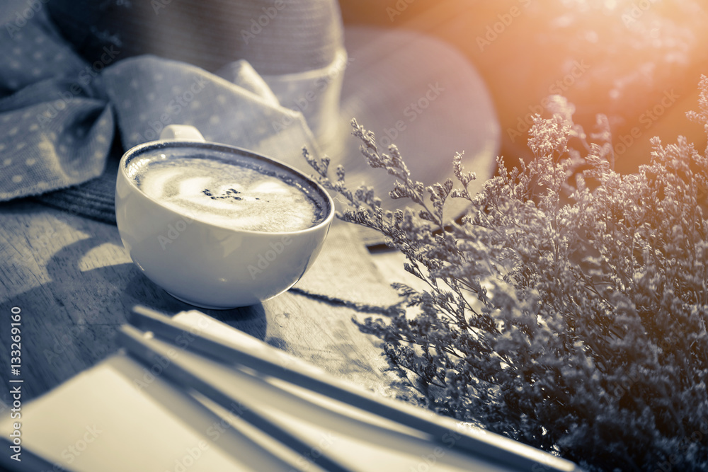 cup of coffee with cinnamon with flower vase background