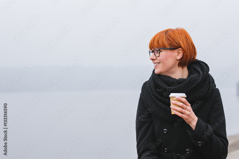 Happy smiling adult tourist girl holding paper coffee cup and en