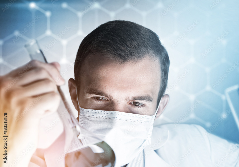 Portrait of concentrated male scientist working with reagents in laboratory