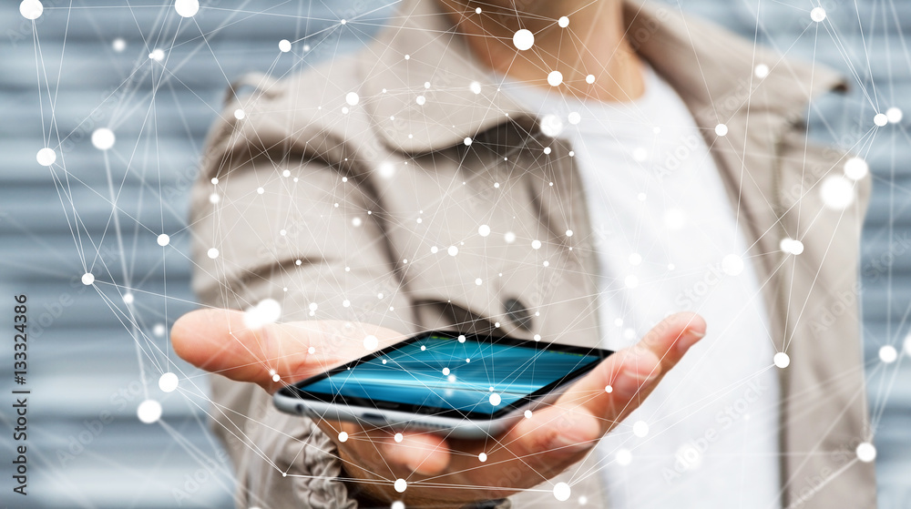 Businessman holding flying network sphere over his mobile phone