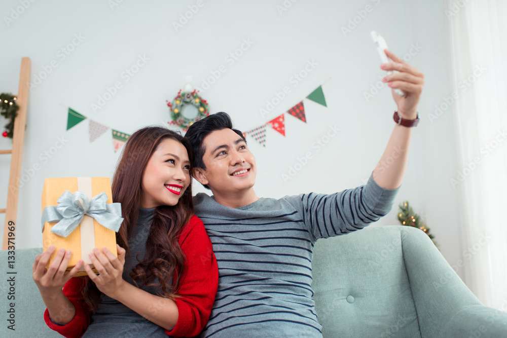 Christmas Asian Couple. A handsome man giving her girlfriend/wif