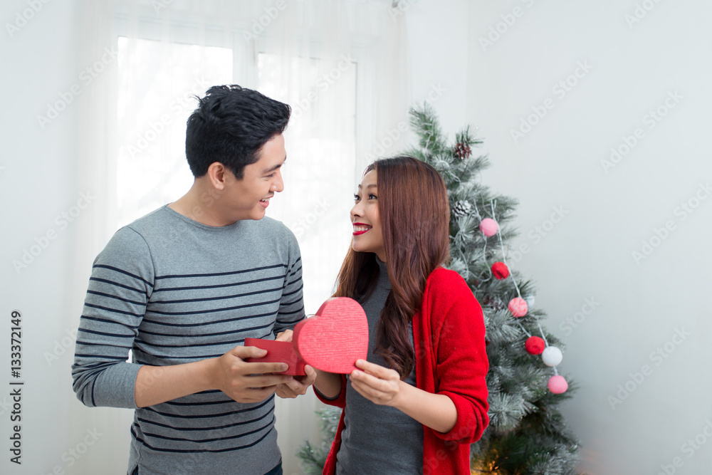 Christmas Asian Couple. A handsome man giving her girlfriend/wif